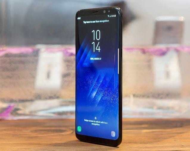 Смартфон Samsung Galaxy S8 со синим экраном на деревянной поверхности