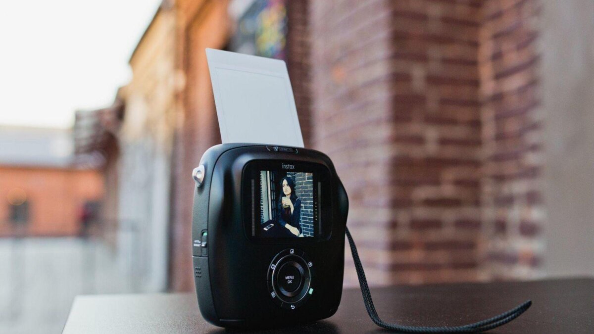 Камера Instax с дисплеем и съемочным модулем на столе