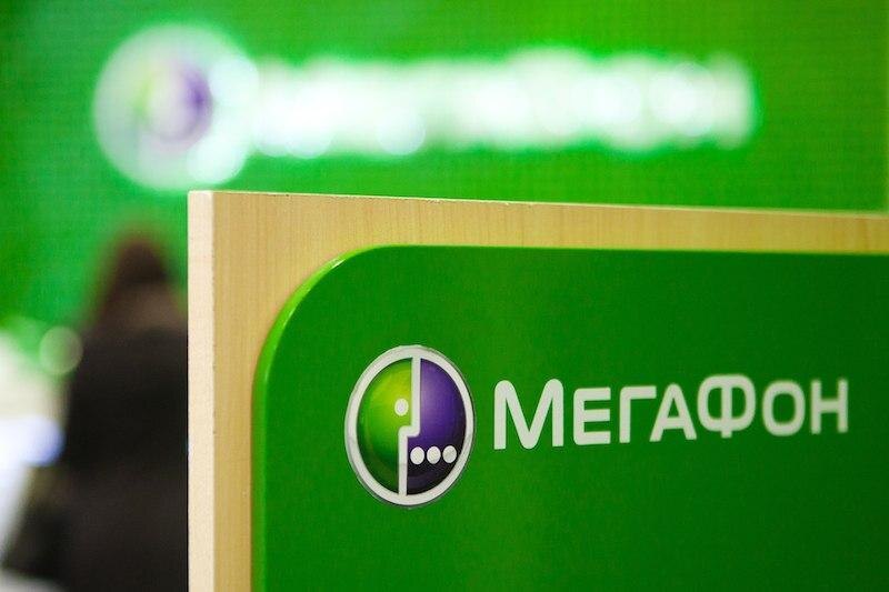 Логотип МегаФон на зеленом фоне с информационным стендом