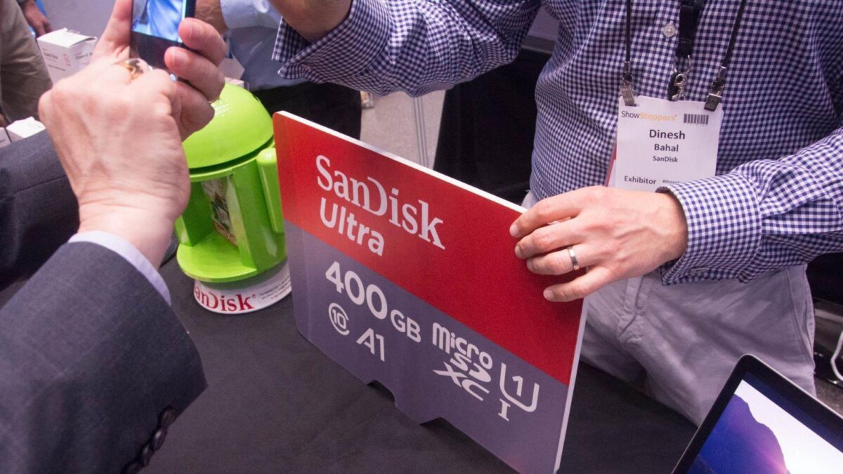 Джентльмен показывает мобильную microSD флешку SanDisk Ultra на выставке IFA 2017
