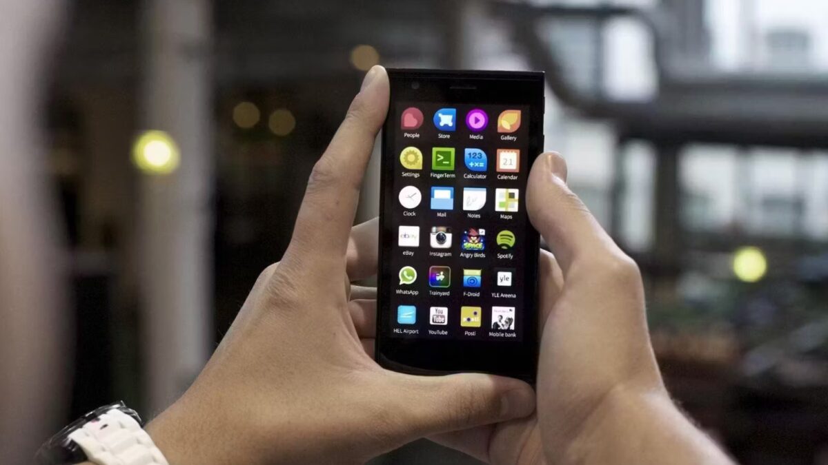 Рука держит смартфон Android с различными приложениями на экране