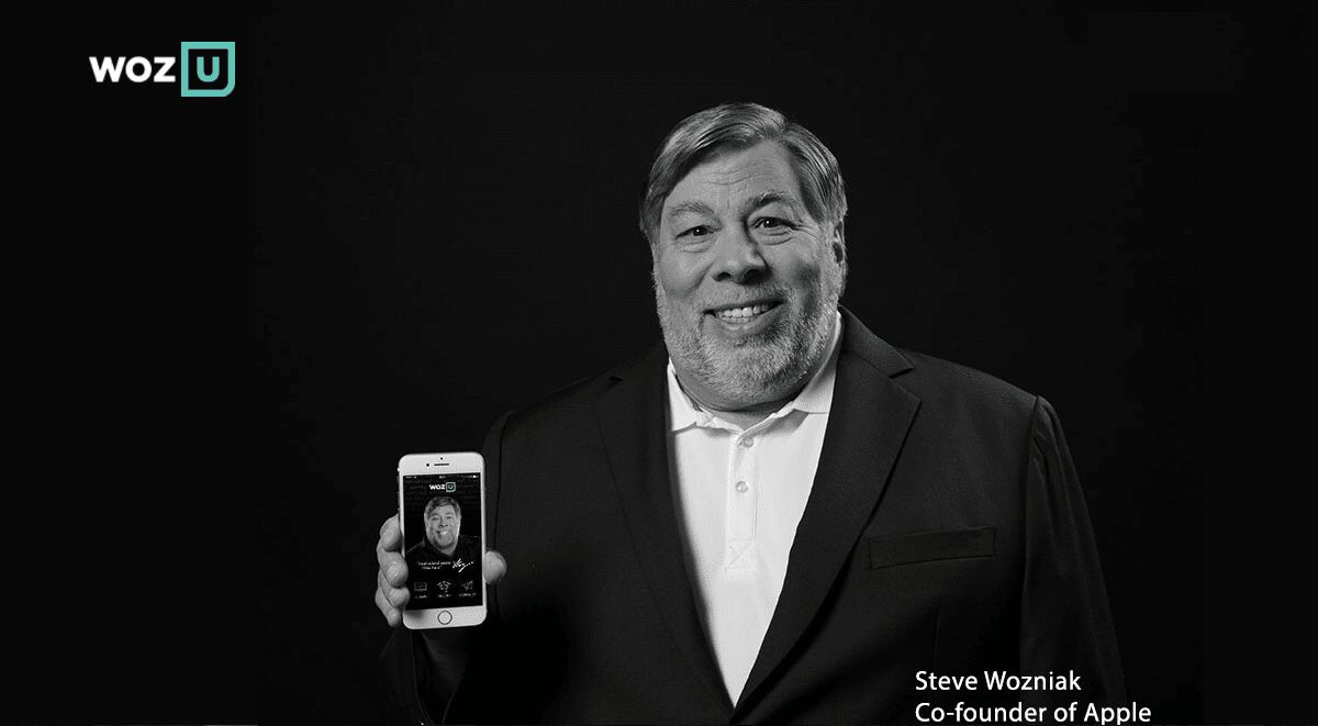 Мужчина в деловом костюме держит iPhone с изображением человека на экране в черно-белом цвете