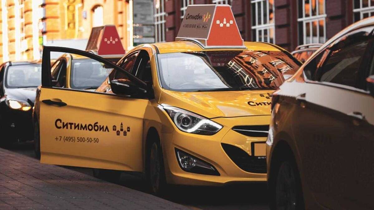 Жёлтая машина такси Ситимобил с рекламой на двери