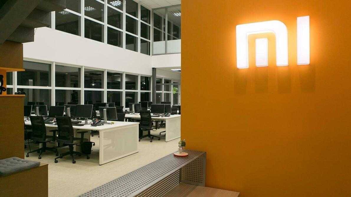 7 лучших гаджетов Xiaomi 2018 года 15 Офис с рабочими местами и логотипом Xiaomi на стене