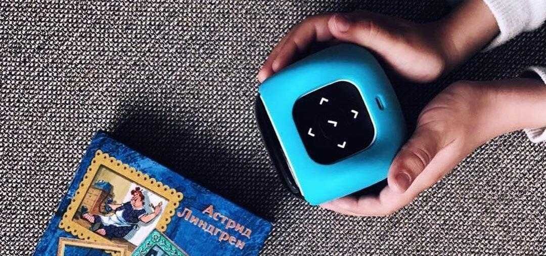 Ребенок держит портативный проектор Cinemood на ткани