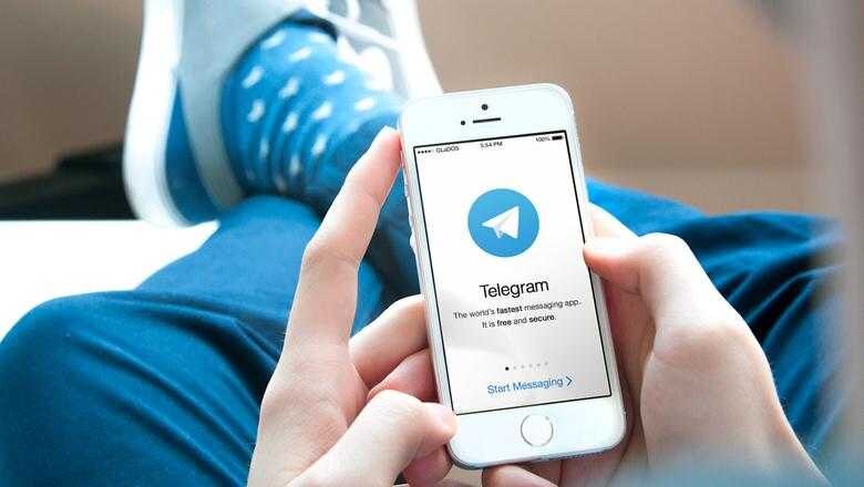 Телефон iPhone с открытым приложением Telegram на экране