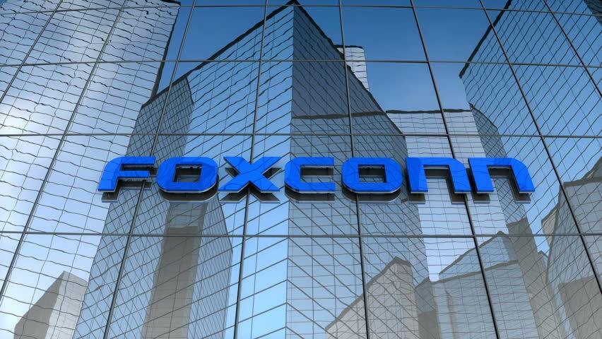 Здание офисного комплекса с отражающими стеклянными фасадами и логотипом Foxconn