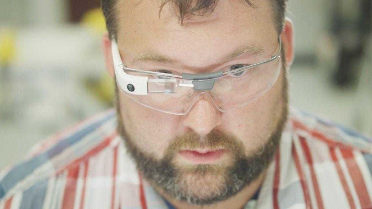 Человек в защитных очках и полосатой рубашке сверху