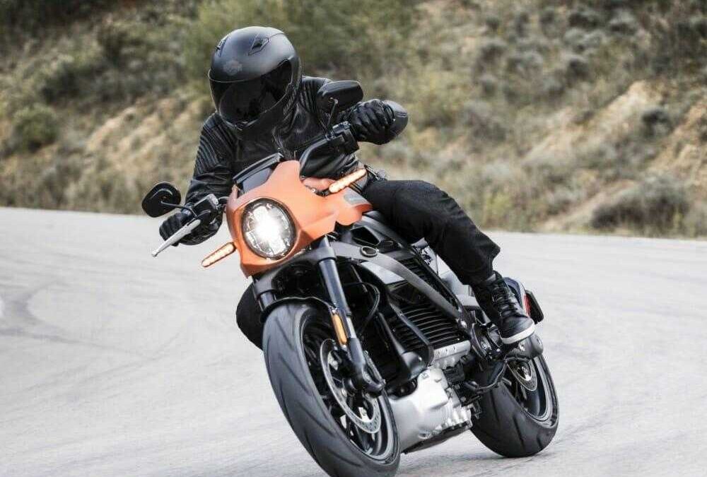 Мотоцикл Harley-Davidson LiveWire с водителем в шлеме и кожаном костюме на повороте