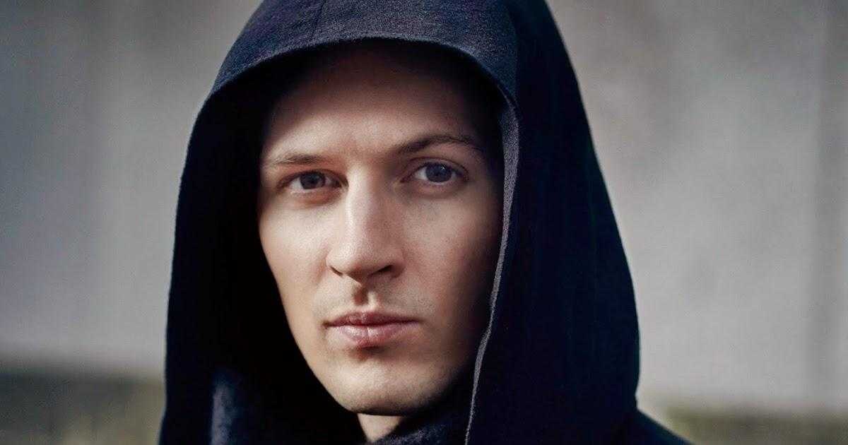 Портрет молодой мужчины в тёмной капюшоне на фоне