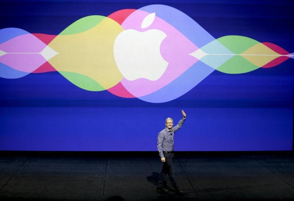 Презентация Apple с крупным логотипом и человек на сцене