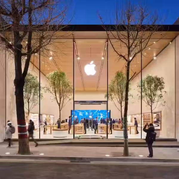 Внутренний вид магазина Apple с посетителями и деревьями