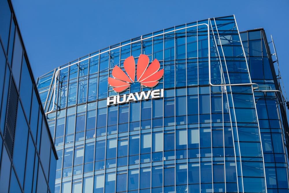 Современное офисное здание с фасадом из стекла и логотипом Huawei