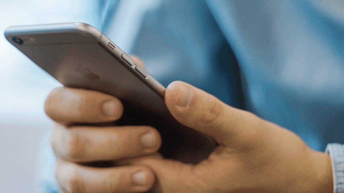 Рука держит смартфон Apple с интерфейсом управления в руках