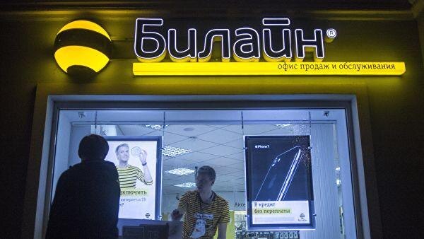 Окно магазина Билайн с сотрудником и рекламой iPhone на заднем плане