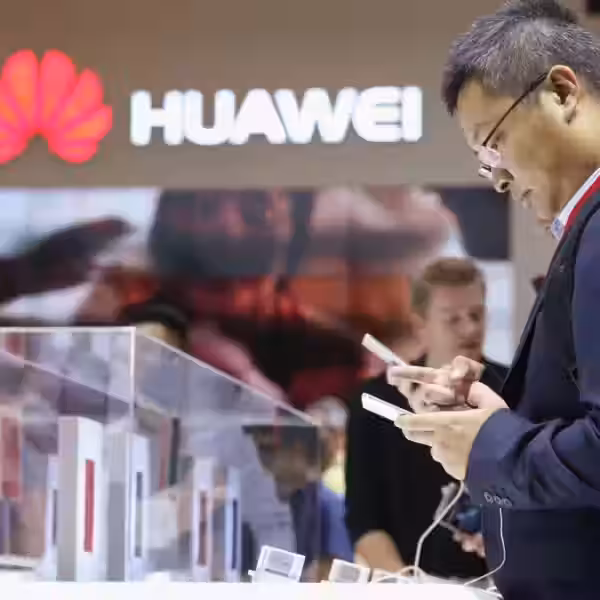 Мужчина в костюме и очках использует смартфон Huawei Mate S