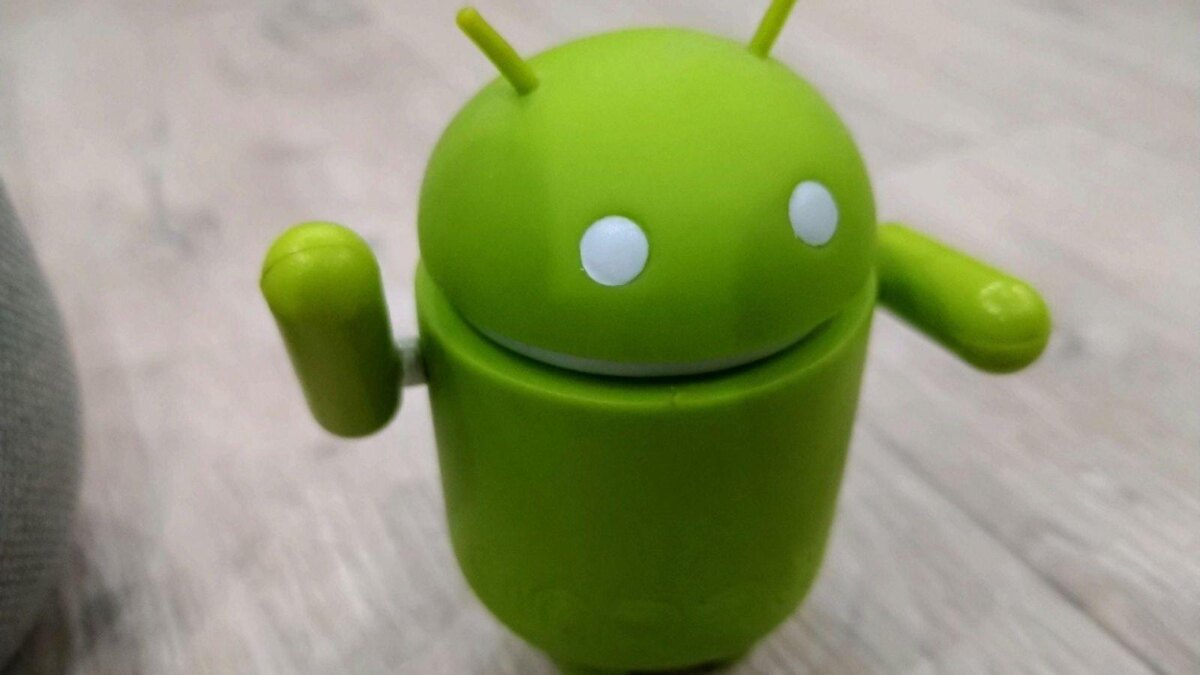 Зеленый миниатюрный робот Android с глазами и рожками