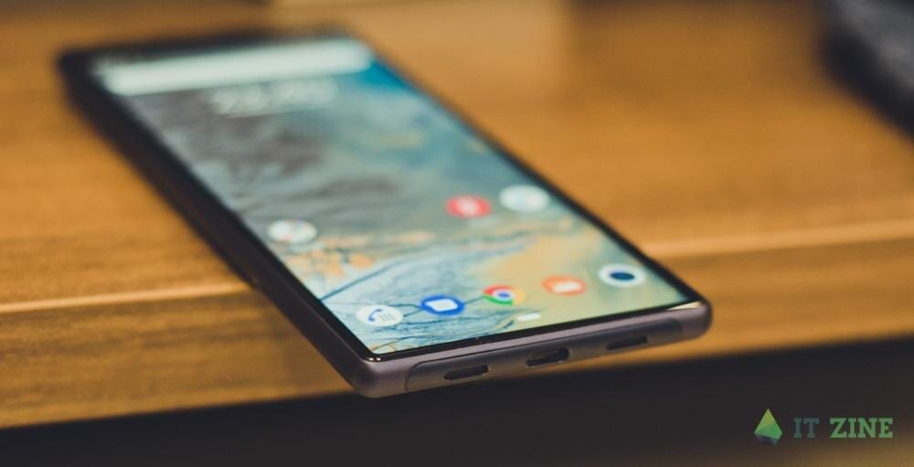 Смартфон iPhone с видимым экраном и интерфейсом