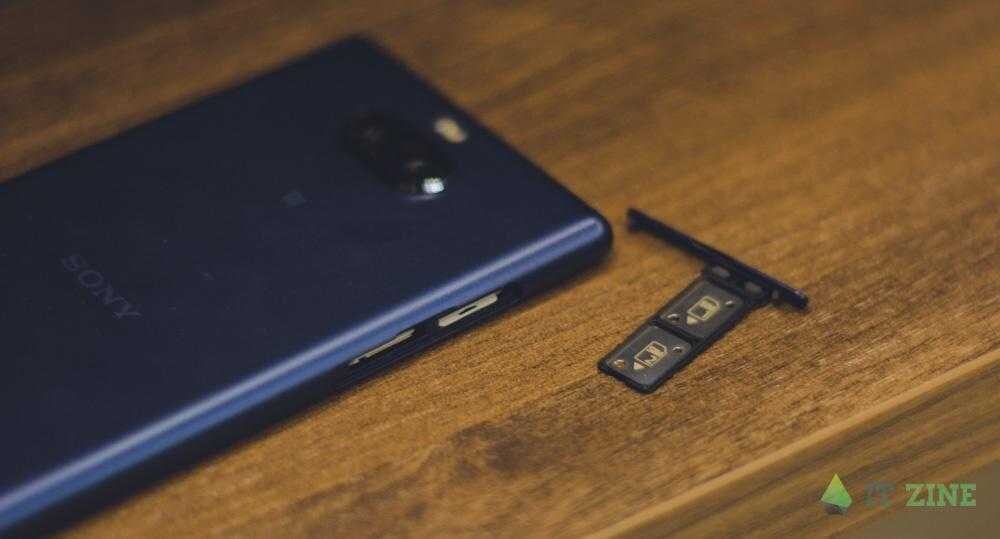 Смартфон Sony и карта SIM на деревянной поверхности