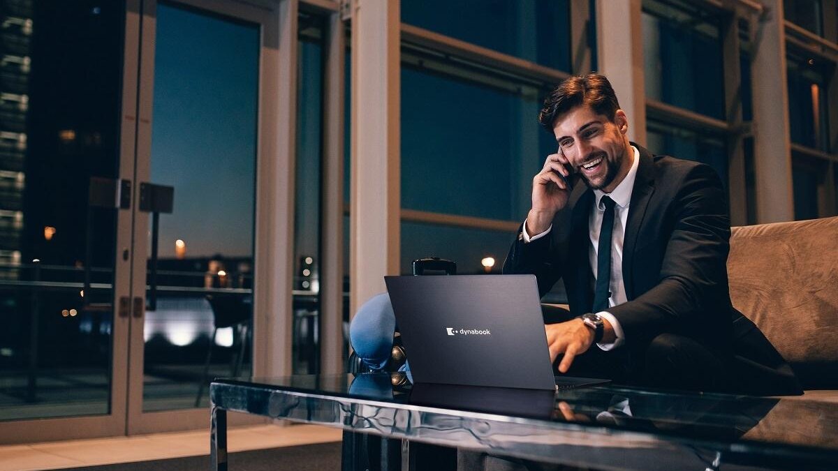 Деловой мужчина в костюме использует ноутбук Dynabook Tecra на презентации