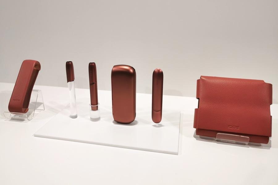 Задняя часть смартфона Tecno Slim с тремя камерами на фоне воды