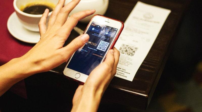 Человек сканирует QR-код на смартфоне в ресторане