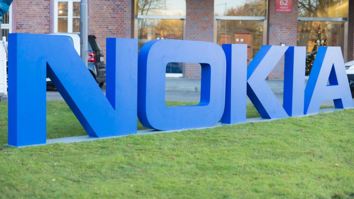 Большая синеая безрамочная вывеска Nokia на зеленом газоне