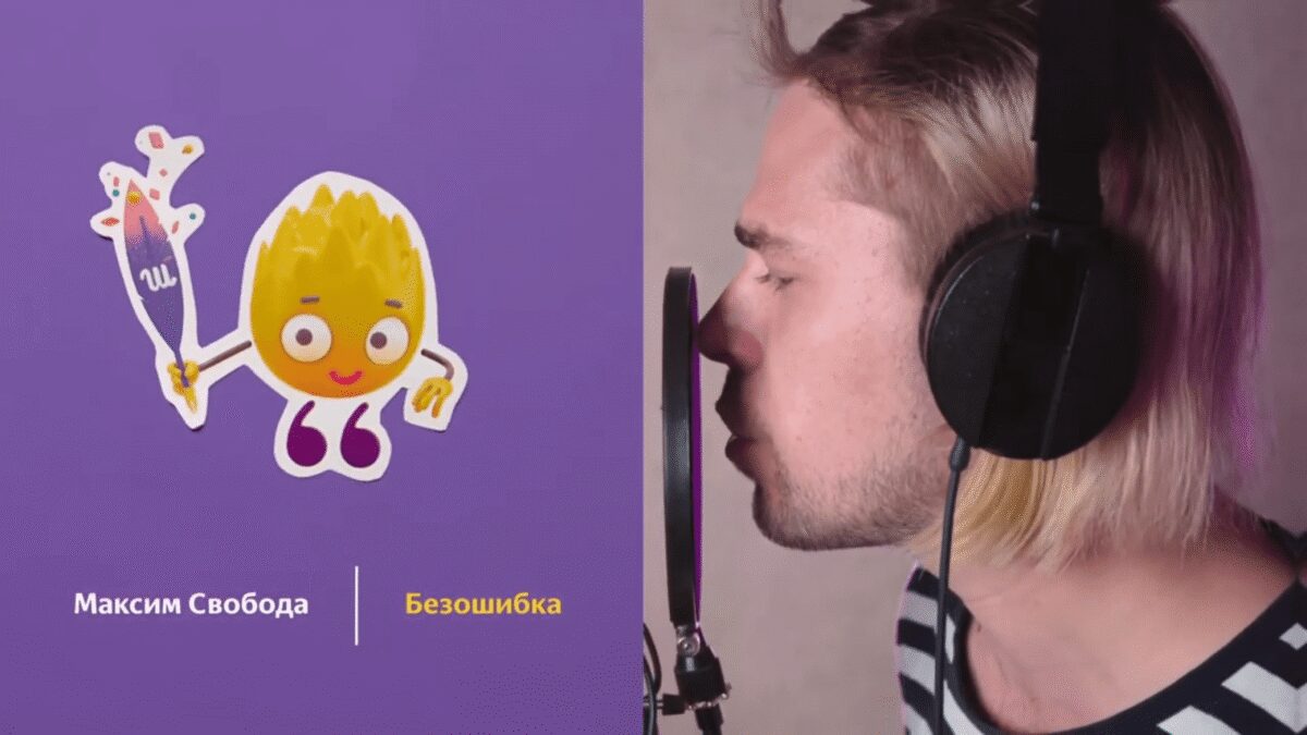 Мужчина в наушниках поет перед микрофоном с изображением мультяшного пламени и шаблонным текстом Максим Свобода Безошибка