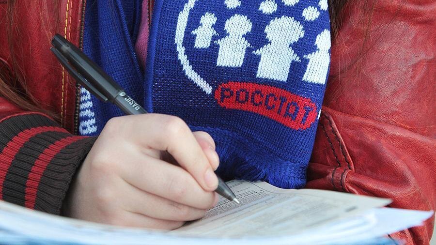 Рука человека пишет ручкой в документе на столе
