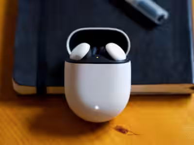 Наушники Google Pixel Buds в открытом кейсе на деревянном столе