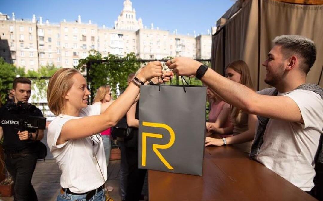 Обмен подарками в ресторане Realme с логотипом R на бумажных пакетах