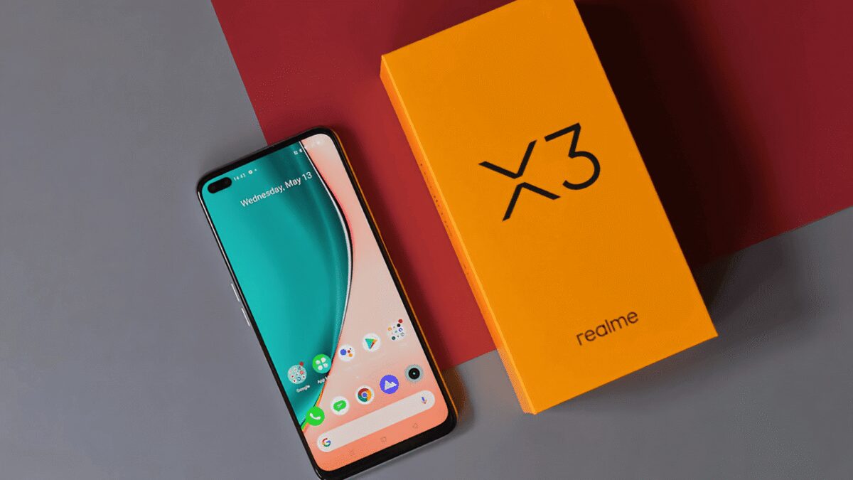 Смартфон Realme X3 SuperZoom на белом столе и коробка ярко-оранжевого цвета