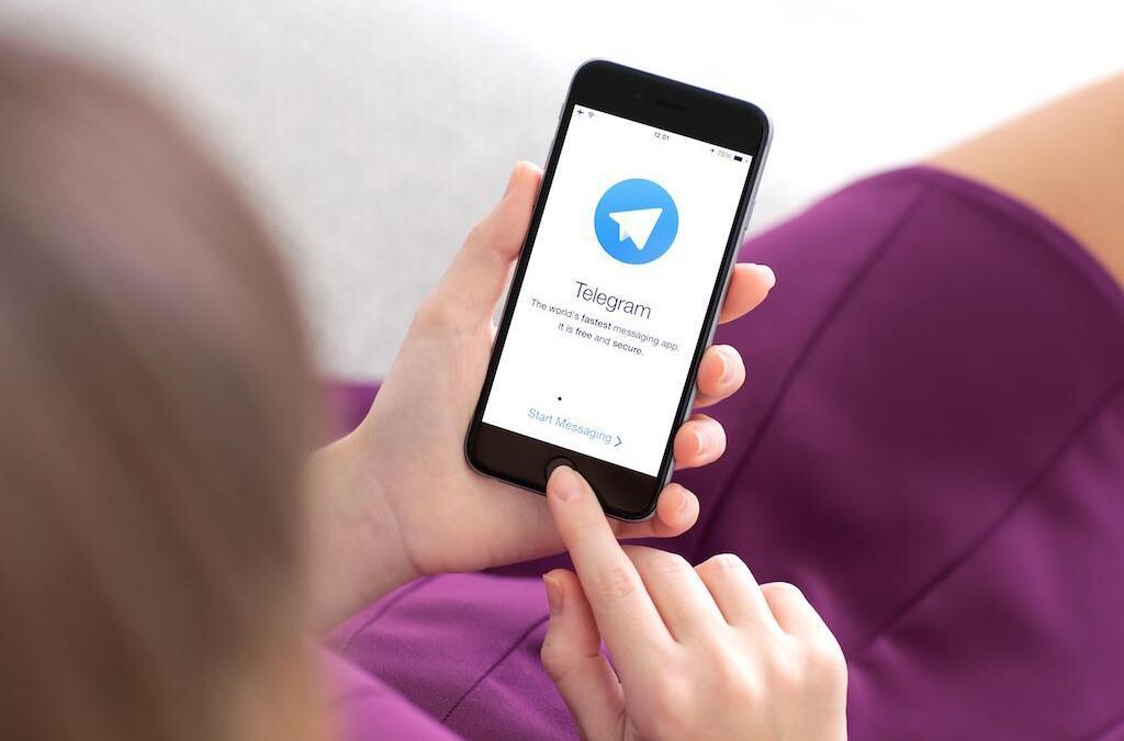 Человек использует смартфон с приложением Telegram