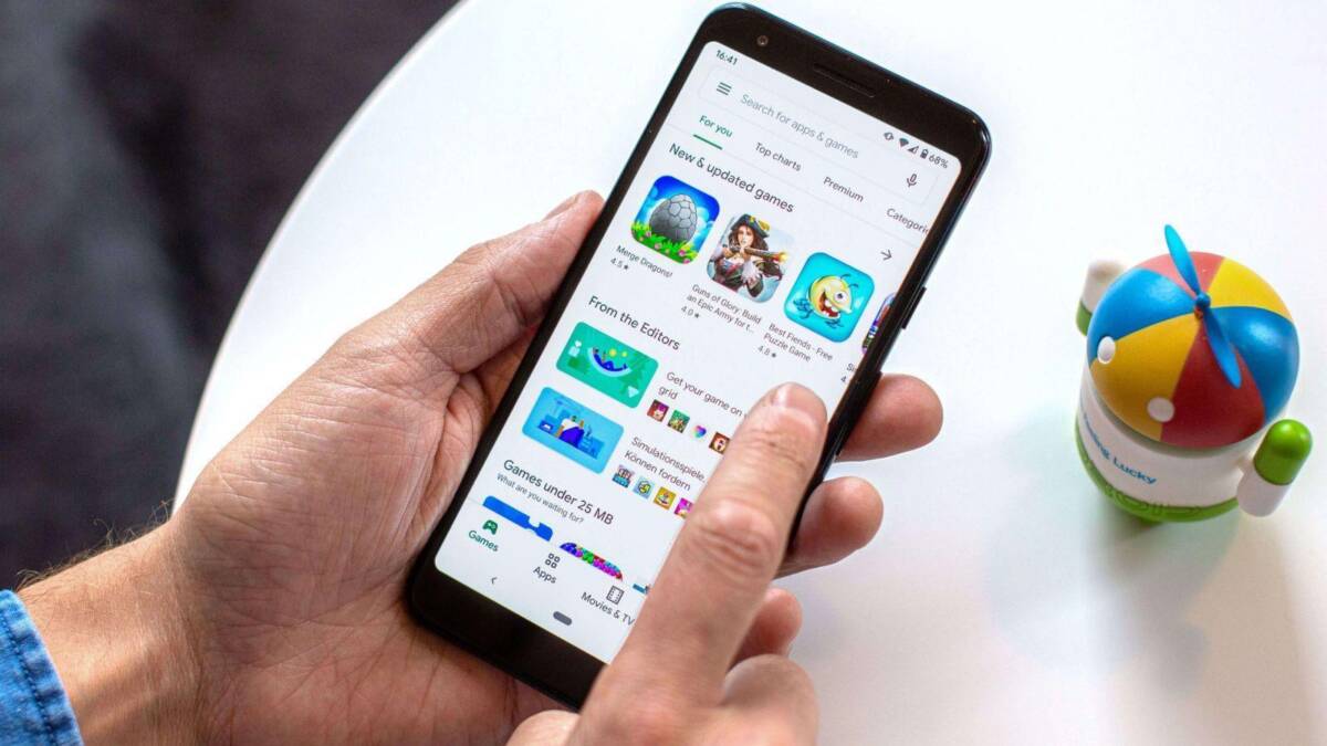 смартфон с открытым магазином Google Play и игрой на экране