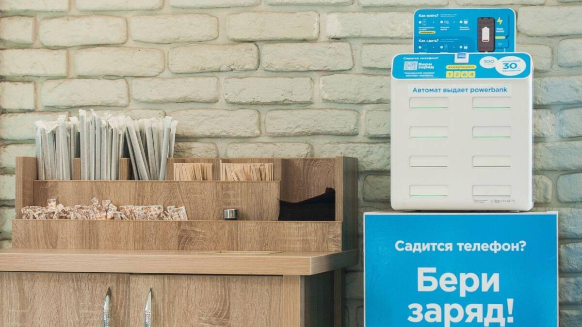 Платформа для зарядки телефона на стенде возле кирпичной стены