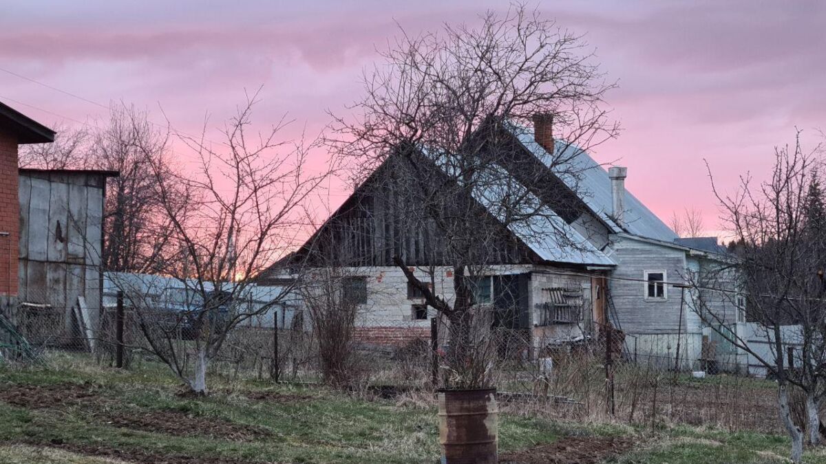 Деревенский пейзаж с старым домом и деревьями в закате