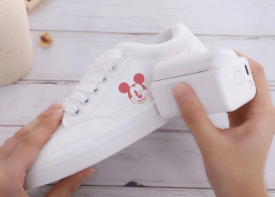 Бело-цветные кроссовки с изображением Микки Мауса на боку человек держит за кабель для включения видеозвонков в Телеграм