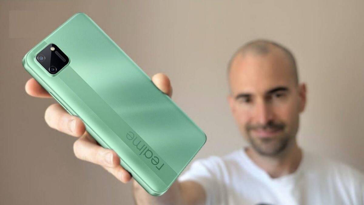 Мужчина держит смартфон Realme C11 сзади