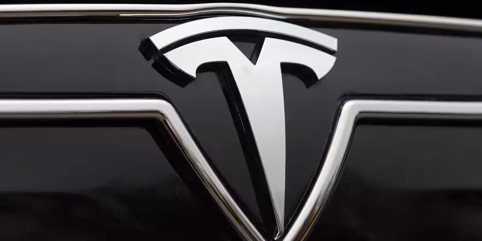 Логотип Tesla на передней маске автомобиля электромобиль