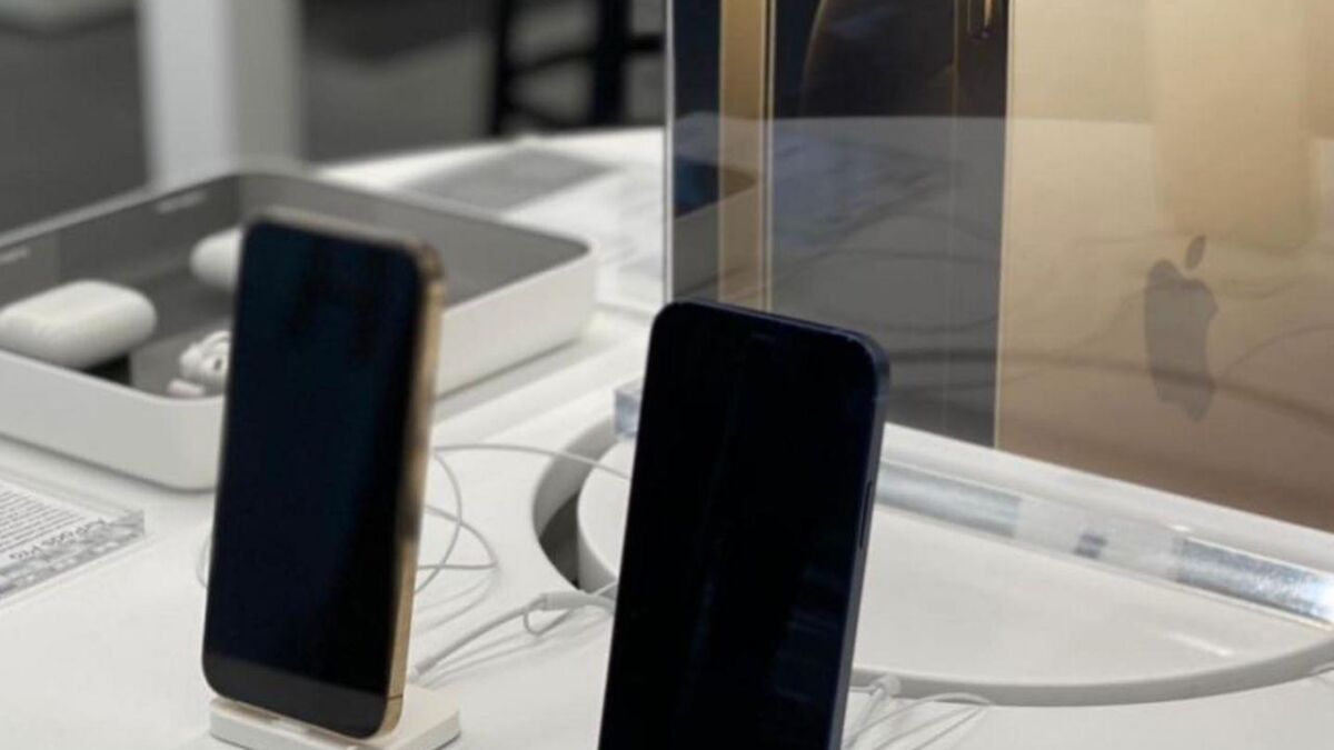 Два iPhone 12 и iPhone 12 Pro на витрине в магазине