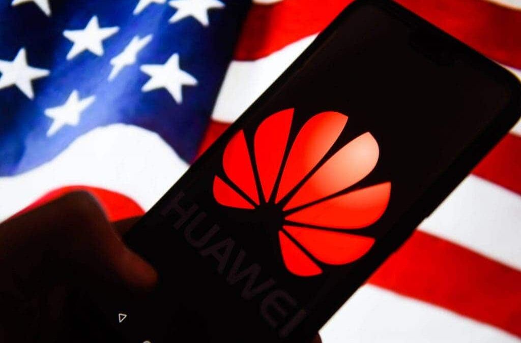 Смартфон Huawei с логотипом на дисплее на фоне американского флага