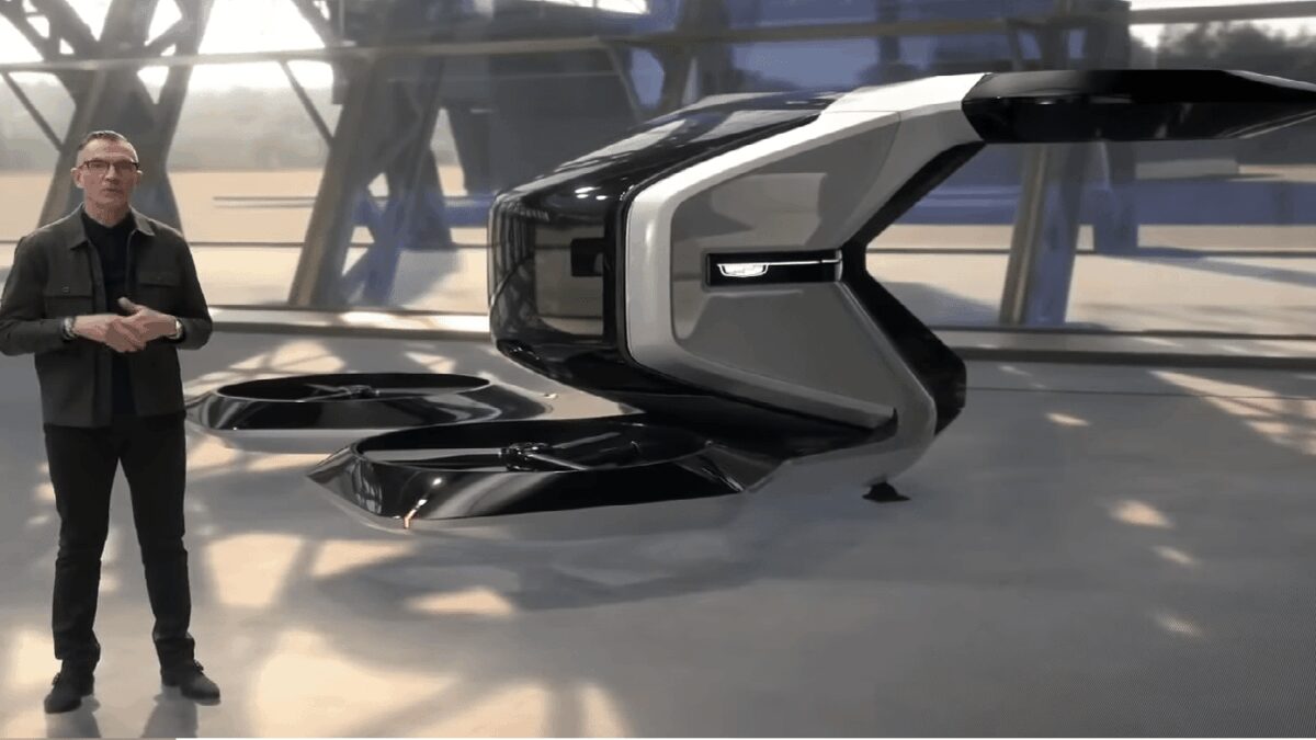 CES 2021: Cadillac-беспилотник, который может взлетать и садиться вертикально 1 Человек рядом с беспилотным вертикальным аппаратом Cadillac на CES 2021