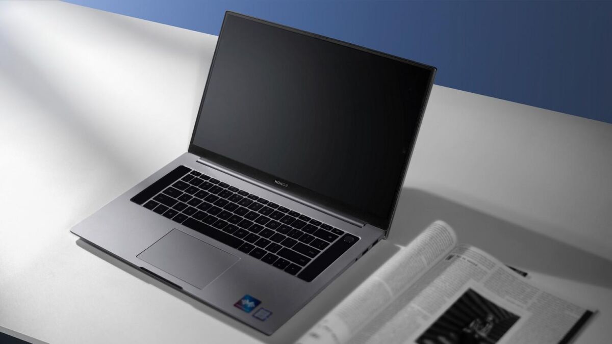 Honor MagicBook Pro показан с открытым экраном на белом столе, корпус и клавиатура крупным планом