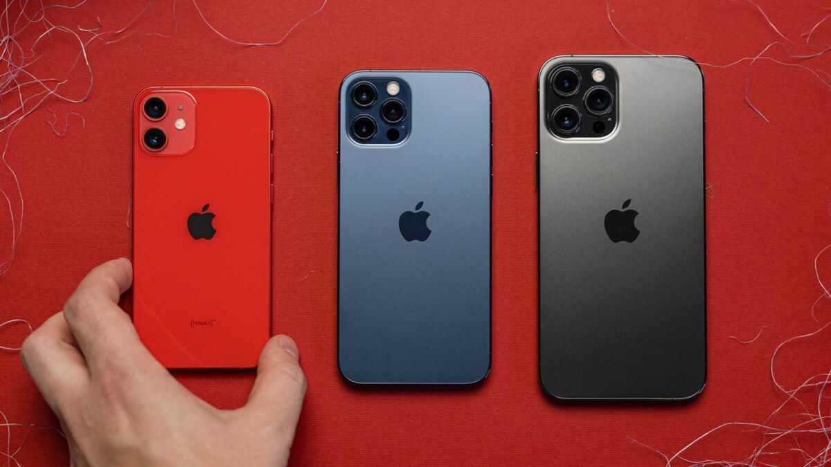 Три смартфона iPhone 12 мини, сзади на красном фоне