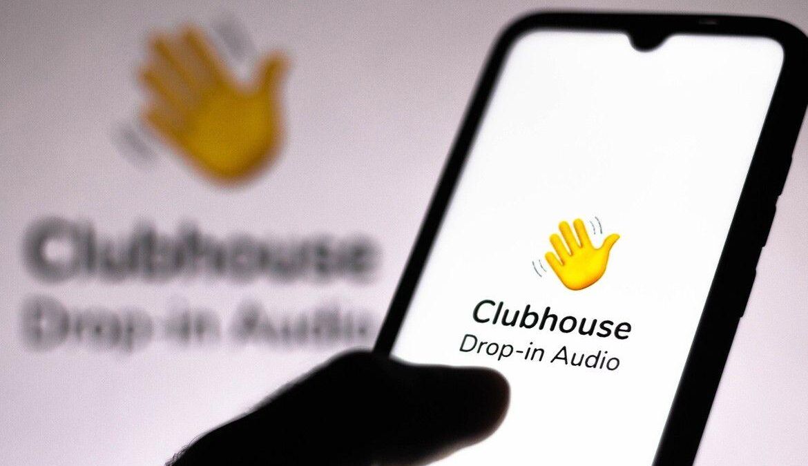 Экран смартфона с приложением Clubhouse: логотип и значок руки на интерфейсе