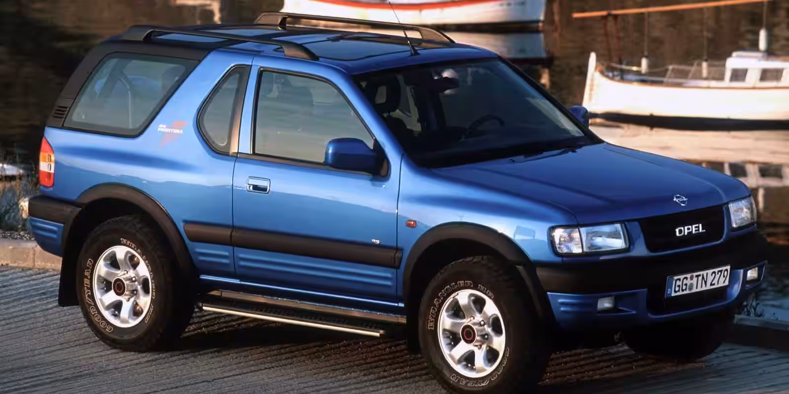Синяя Opel Frontera с бамперами и шинами на переднем плане