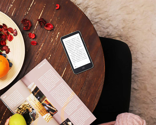 Электронная книга Xiaomi на деревянном столе с журналом и фруктами