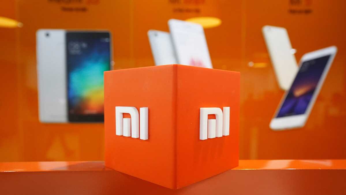 Яркая оранжевая витрина с логотипом Xiaomi и смартфонами на заднем плане