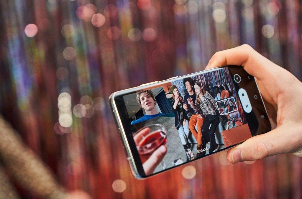 Человек снимает людей на смартфон Samsung Galaxy S22
