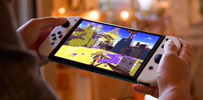 Игрок держит Nintendo Switch с OLED-экраном в руках